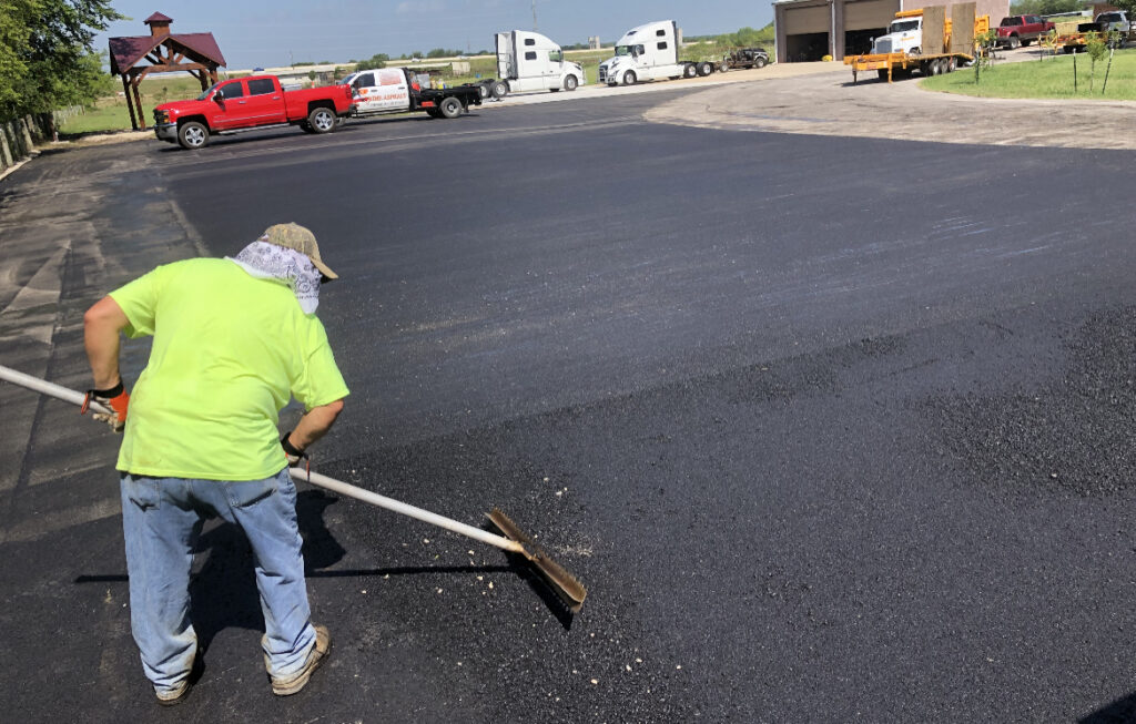 Raking asphalt by hand along a new lot