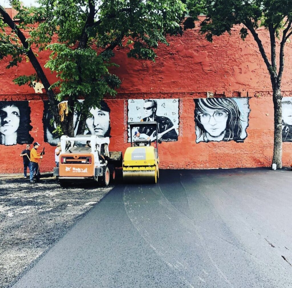 Paving an alley beside a downtown mural