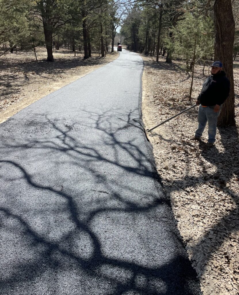 Finished asphalt driveway shaded by oak trees