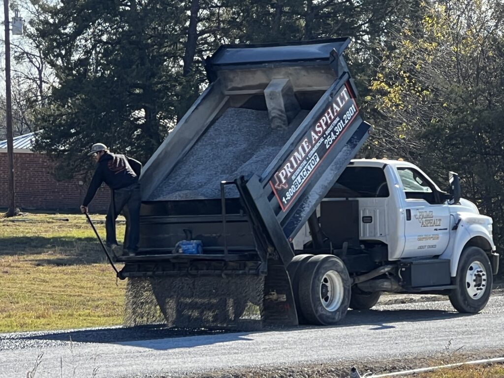 Dump truck spreading stone for a chip seal road