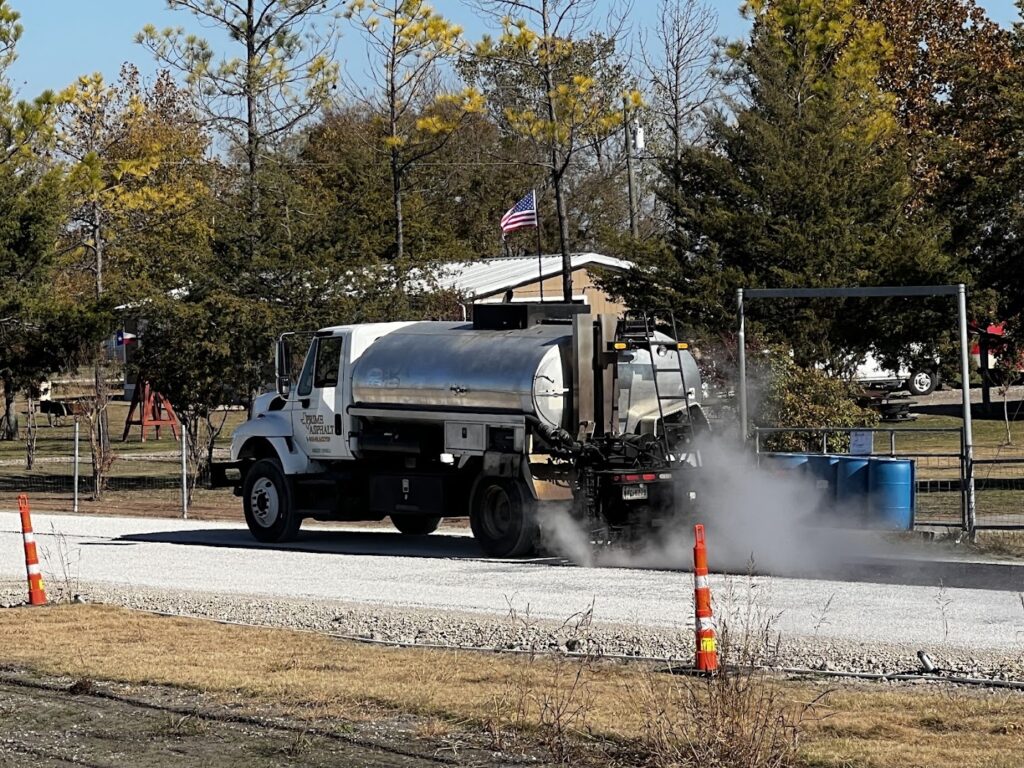 Distributor truck spraying hot liquid asphalt for a chip seal